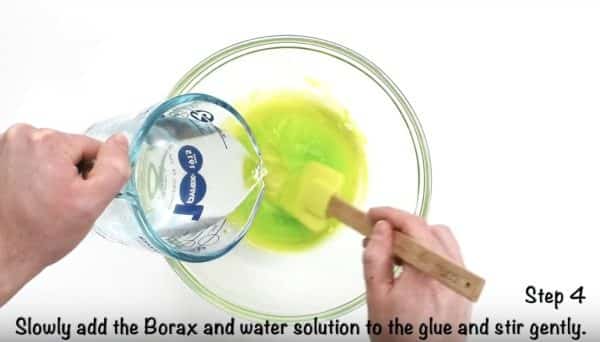 pouring Borax and water solution into bowl of green clear glue