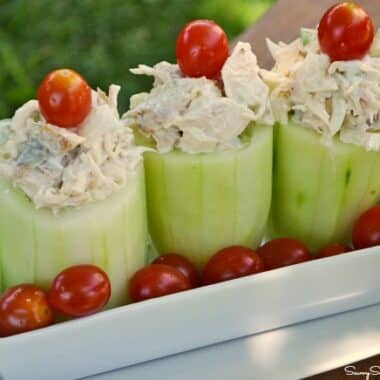 Cucumber Cups stuffed with chicken salad with a cherry tomato on top.
