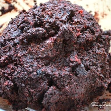 Red holiday Oreos and cream cheese blended in a bowl.
