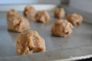 Raw peanut butter cookie balls on a baking sheet.