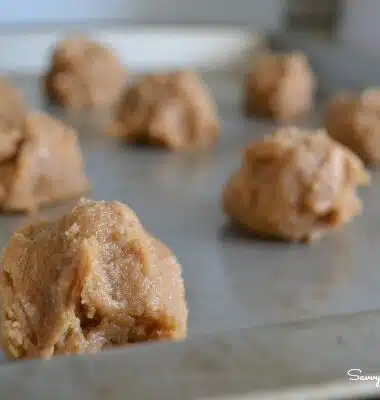 Raw peanut butter cookie balls on a baking sheet.