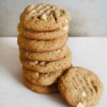 Flourless Peanut Butter Cookies stacked on white table.