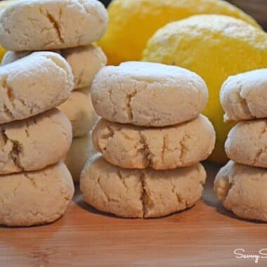 Baked crinkle style lemon almond flour cookies on a wooden cutting board.