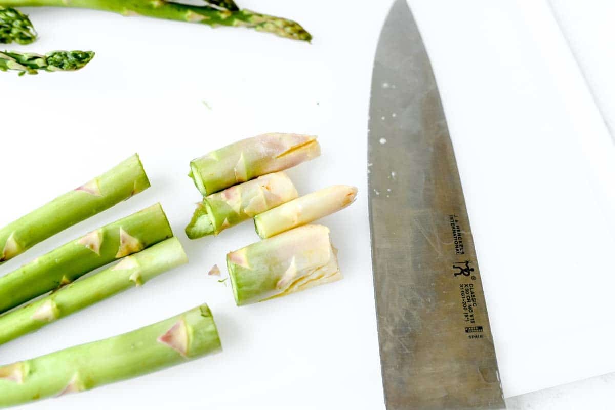 A sharp knife near cut off asparagus tips.