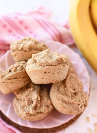 Oatmeal and banana muffins on a pink plate.