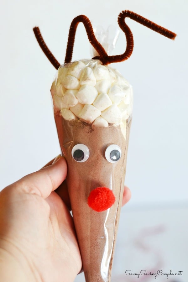 Reindeer Hot Cocoa Cones with wiggly eyes, brown pipe cleaner antlers in someone's hand. 