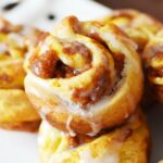 pumpkin cinnamon roll with glaze dripping down