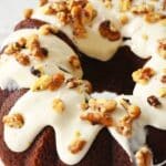 Banana cream cheese frosting with walnuts on a bundt cake.