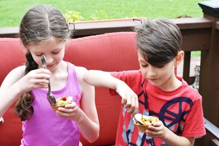 Kids eating fruit and yogurt cups 
