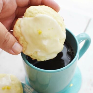 Lemon Ricotta Cookie being dipped into a blue mug of black coffee.