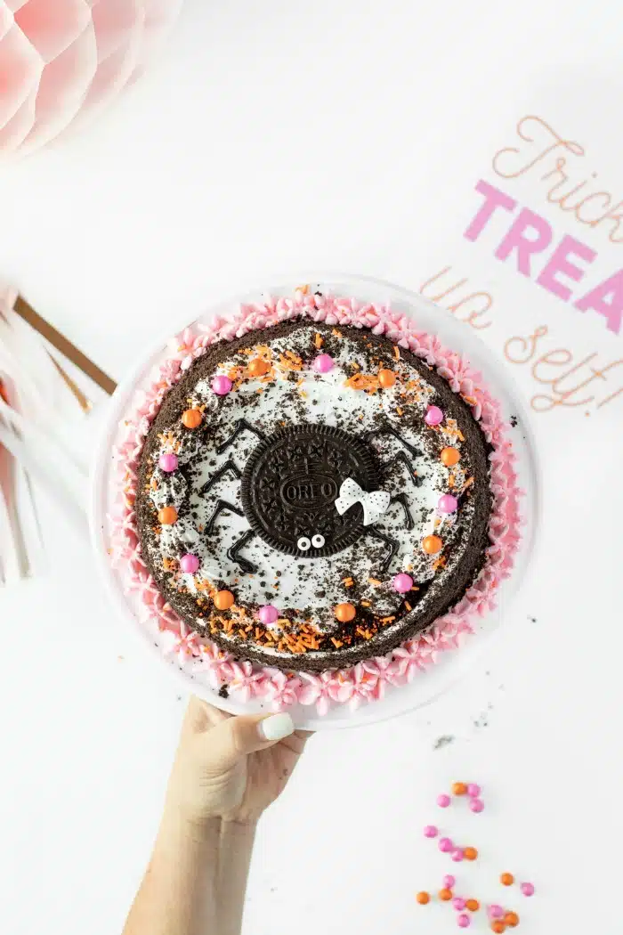 Pink and Orange Halloween Oreo Ice Cream cake in someone's hand.