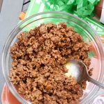 Slow cooker Taco beef in a clear, glass bowl with a spoon.