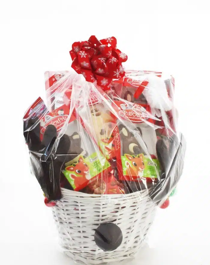Wrapped Reindeer Gift basket with antlers on white table. 