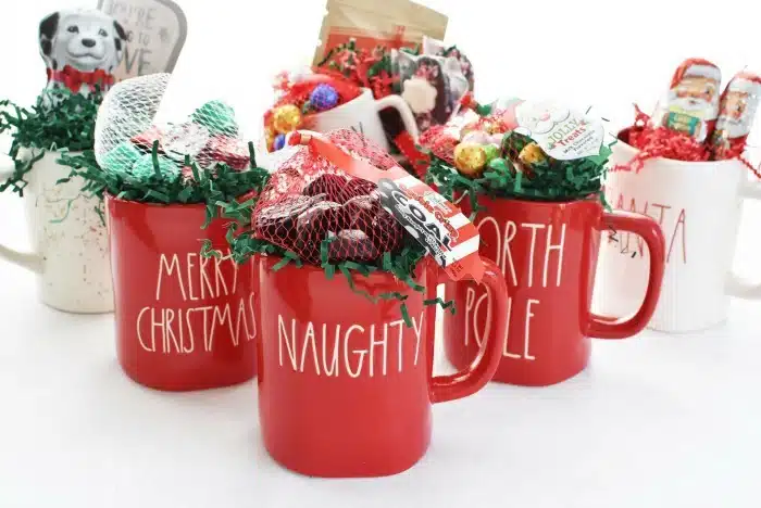 Rae Dunn Christmas mugs filled with candy. 