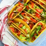 Chicken Taco Bake with red striped napkin in a glass casserole dish
