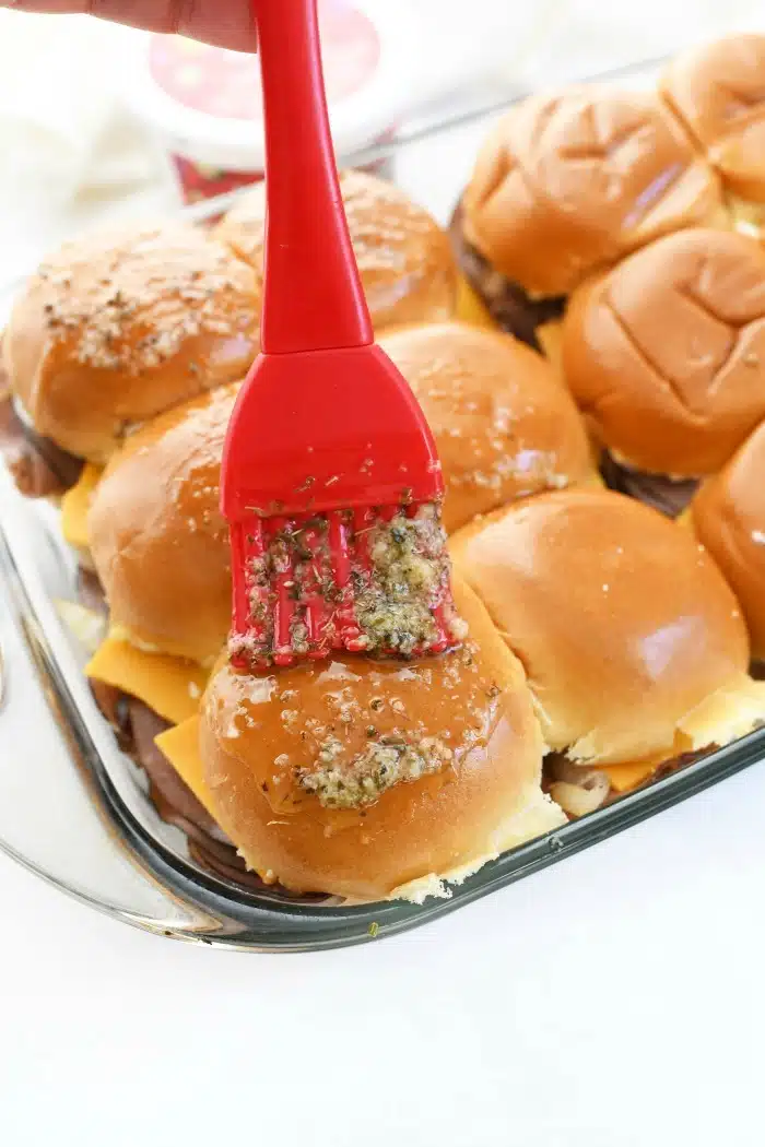 Garlic Butter brushed sliders with red, rubber brush.