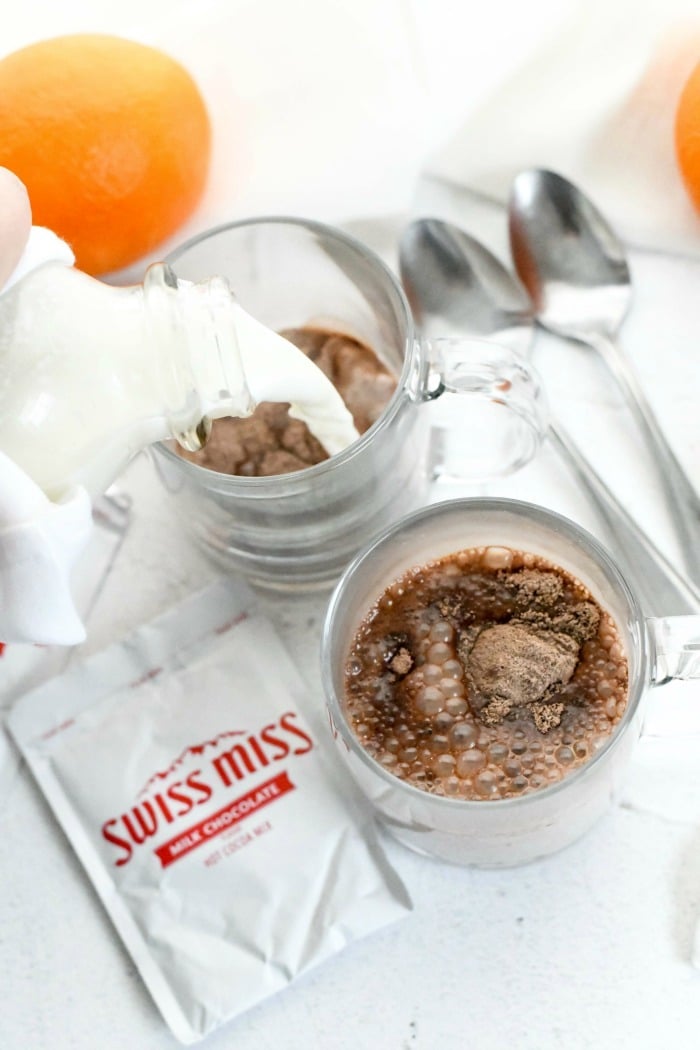 Swiss Miss Cocoa with milk pouring into glass. 