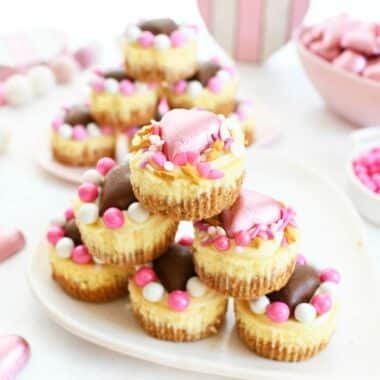 Valentine's Day White Chocolate Ganache Cheesecakes with heart candies and sprinkles stacked,