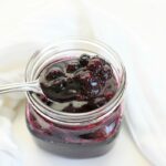 Fresh Blueberry compote with a silver spoon and white napkin.