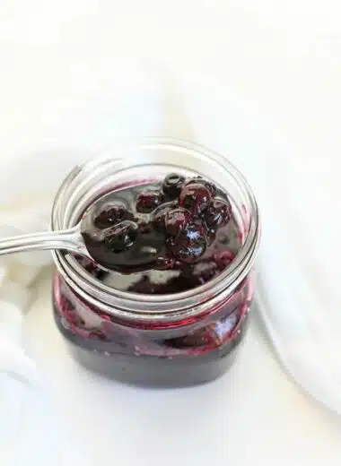 Fresh Blueberry compote with a silver spoon and white napkin.