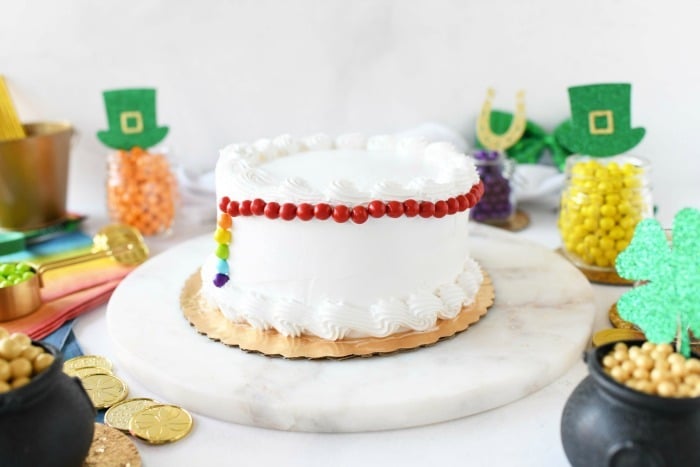 White cake lined with colorful Sixlets. 