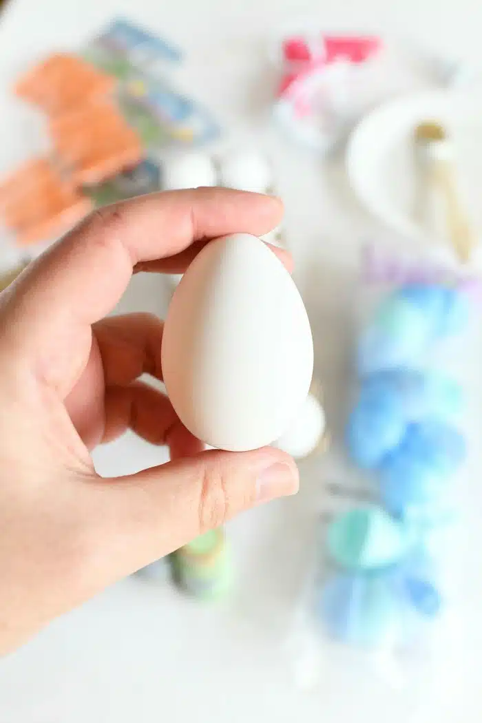 White craft egg in hand. 