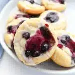 Blueberry danish on a white plate with blue napkin.