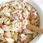 Seafood Cold Pasta Salad with wooden spoon in white dish