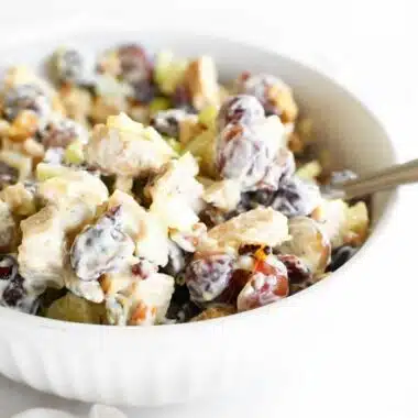 Chicken with Grapes salad in a white dish with a spoon.