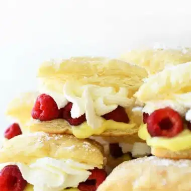 Raspberry Lemon Cream Puffs stacked on each other on a white tray.
