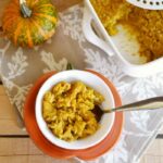 Baked Pumpkin oatmeal in a small white bowl with a spoon on a wooden table.
