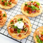 Tostadas on a wire rack with fresh topppings.