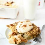 Baked apple oatmeal on plate with yogurt served on top.