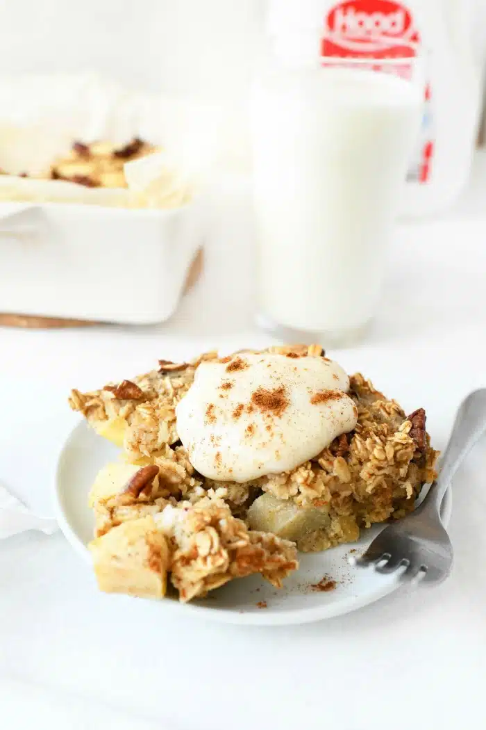 Baked apple oatmeal on plate with yogurt served on top.