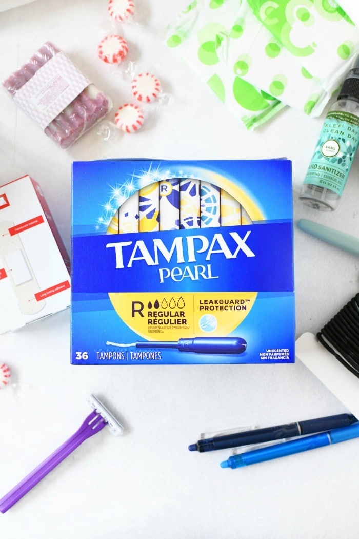 Tampax Pearl on table with hair and body care products.