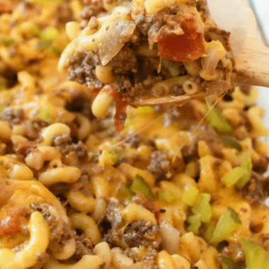 A hearty scoop of Cheeseburger Casserole on a wooden spoon.