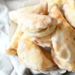 Apple Hand Pies on a white stand with a gray napkin.