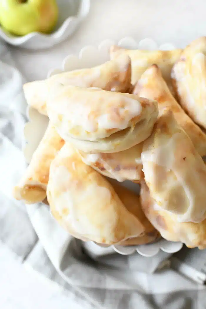 Apple Hand Pies on a white stand with a gray napkin. 