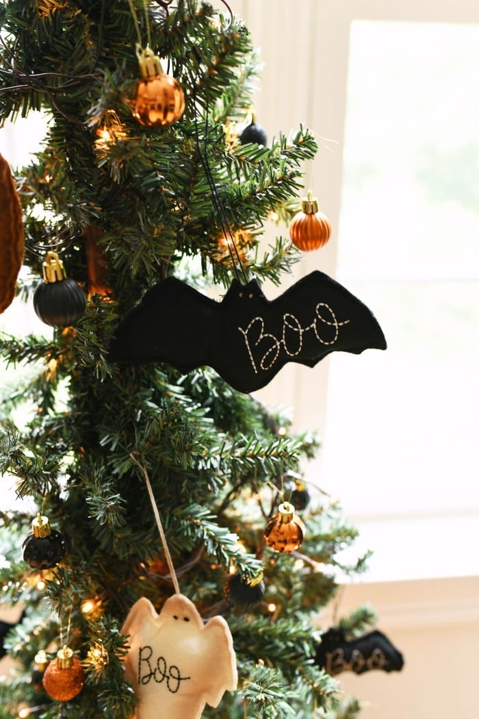 Boo bat felt black ornament on a slender tree.