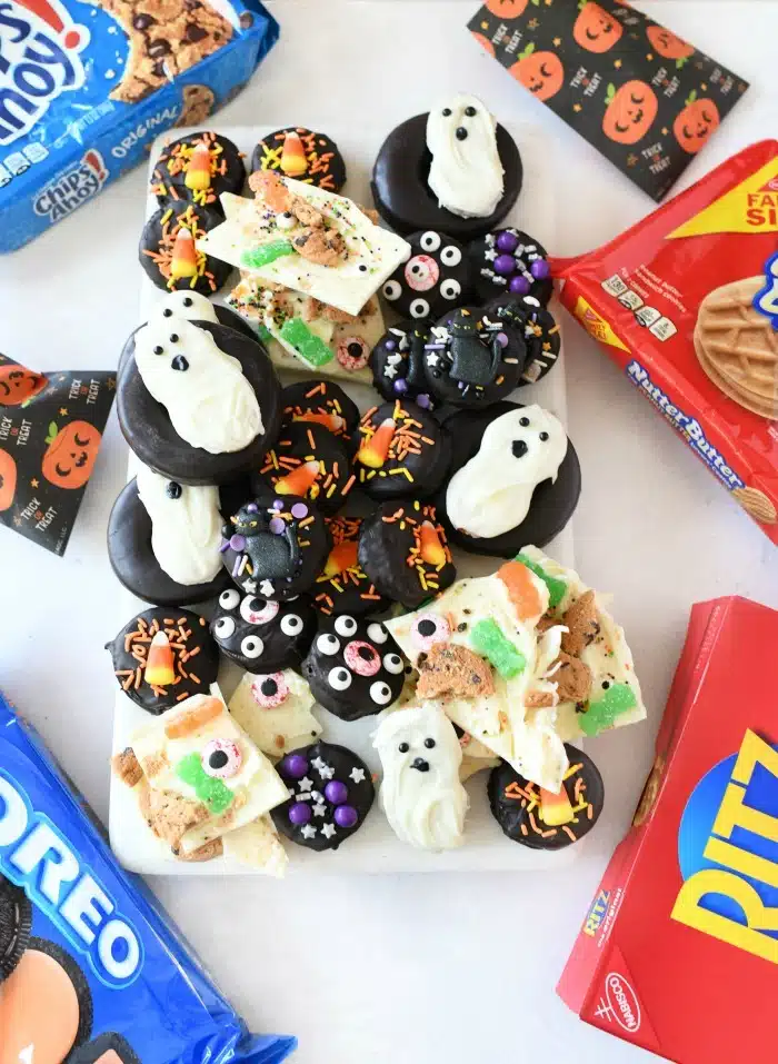 Halloween semi-homemade snacks on a white tray with cookie boxes around the tray.