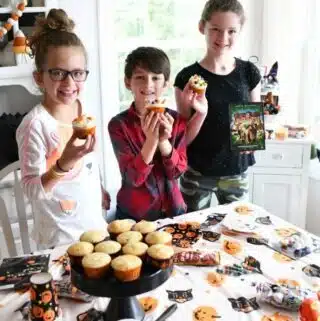 Kids decorating Halloween Cupcakes at a Halloween party.