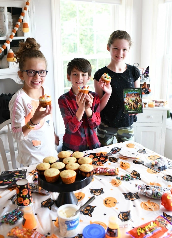 Kids decorating Halloween Cupcakes at a Halloween party.