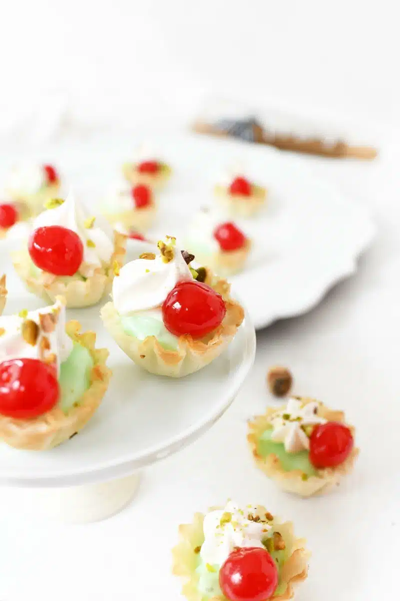 Christmas desserts with cherries on a white platter.