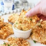 Ritz Cracker Crusted Chicken cutlets being dipped in ranch.