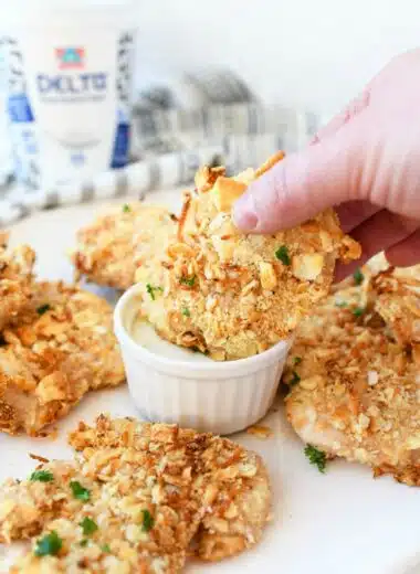 Ritz Cracker Crusted Chicken cutlets being dipped in ranch.