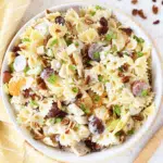Tropical Chicken Salad with Pineapple in a white bowl with a yellow napkin nearby.