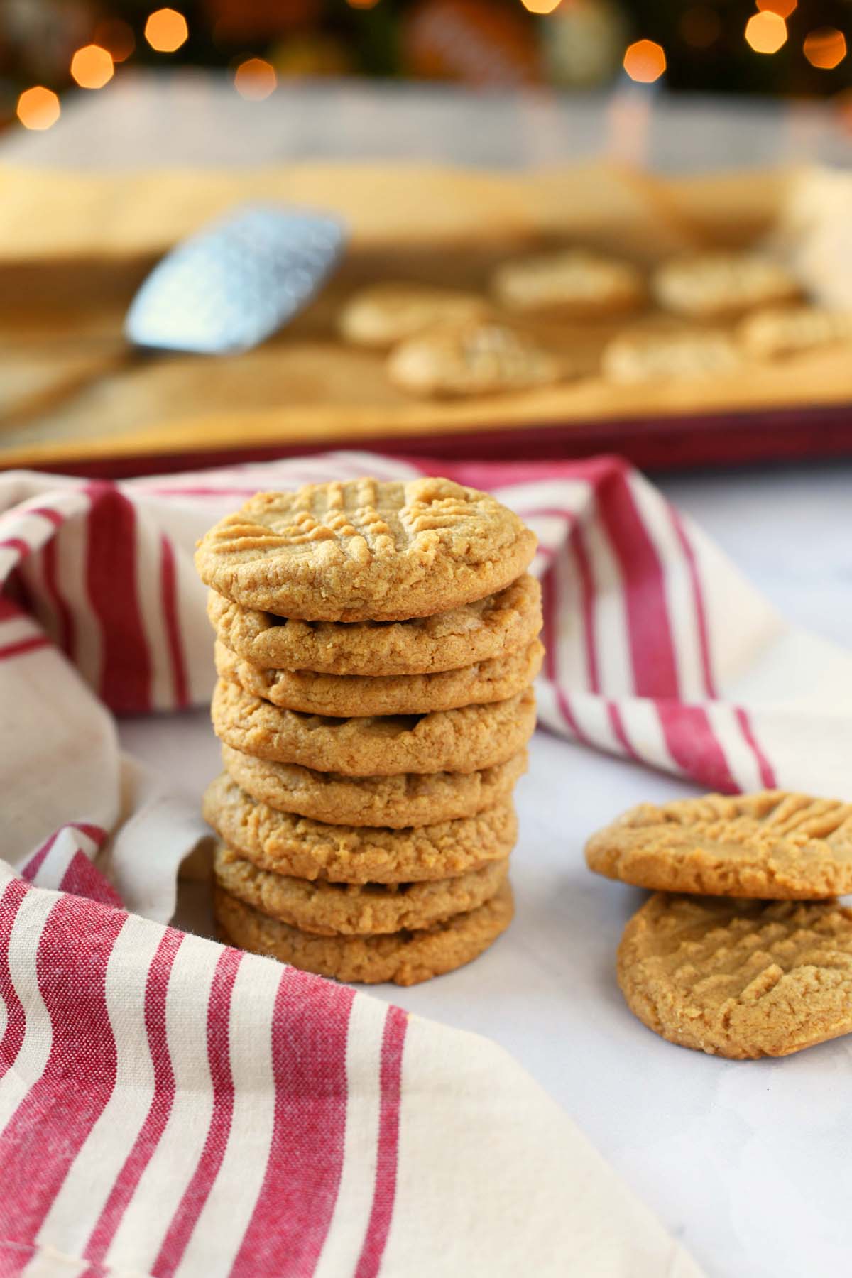 A stack of 3 ingredient peanut butter cookies near a red, striped napkin.