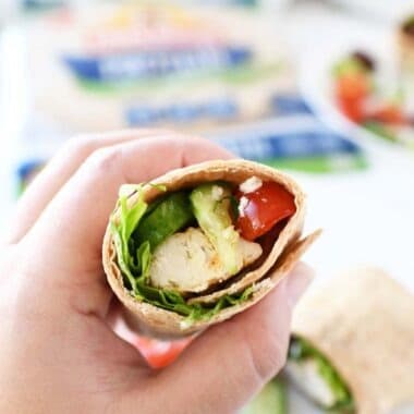 Greek Wrap recipe in someone's hand showing inside the wrap.