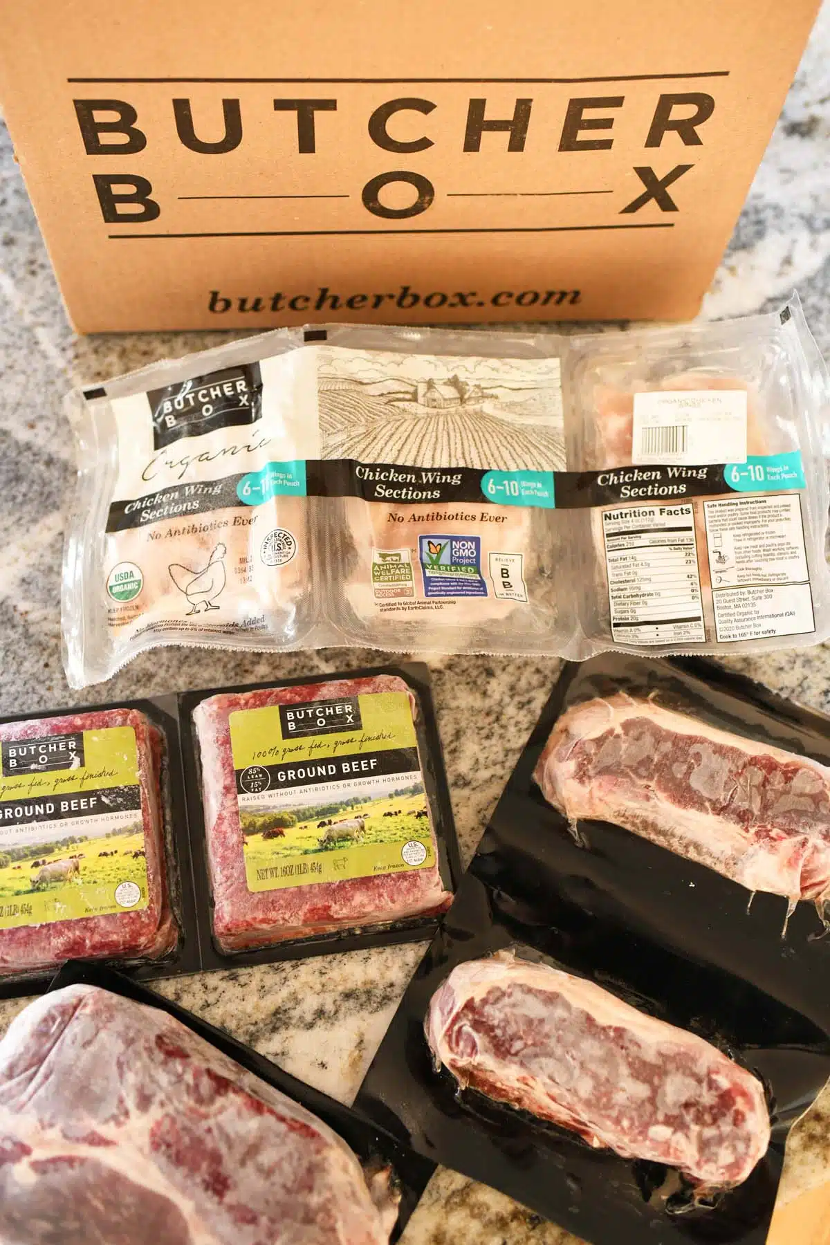Butcher Box Beef Box ona  counter with frozen cuts of meat nearby.