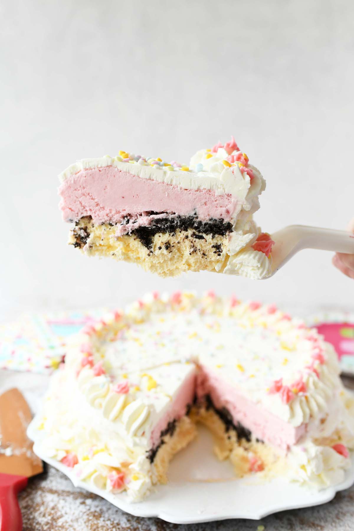 Homemade Strawberry Vanilla Ice Cream Cake on a white cake spatula.
